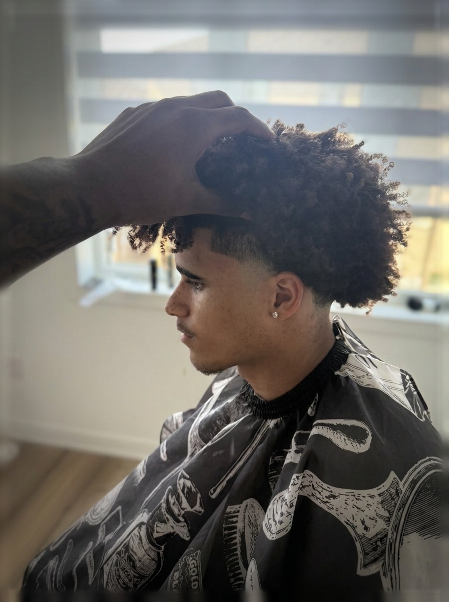 Textured curly top with a clean low taper